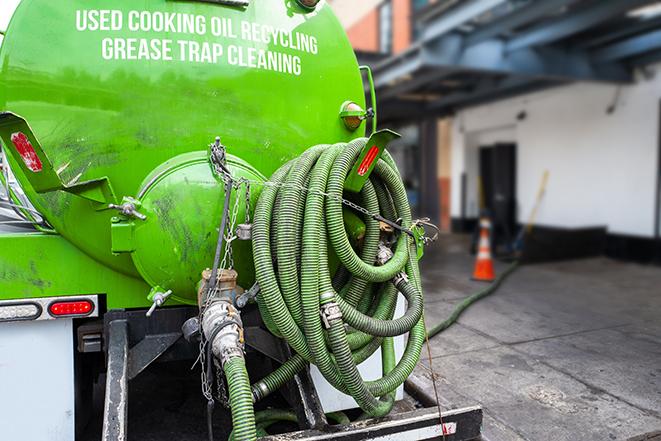 a grease trap being pumped by a sanitation technician in Yalaha, FL